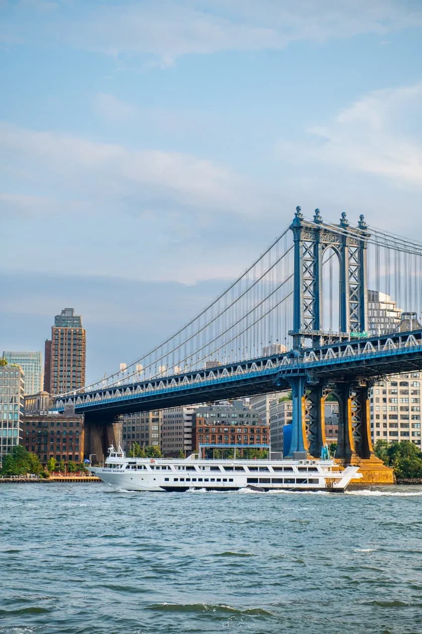 Grande Mariner passing beneath the Manhattan Bridge on a clear day, DUMBO behind